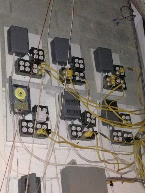 A bunch of wires are hanging from a wall