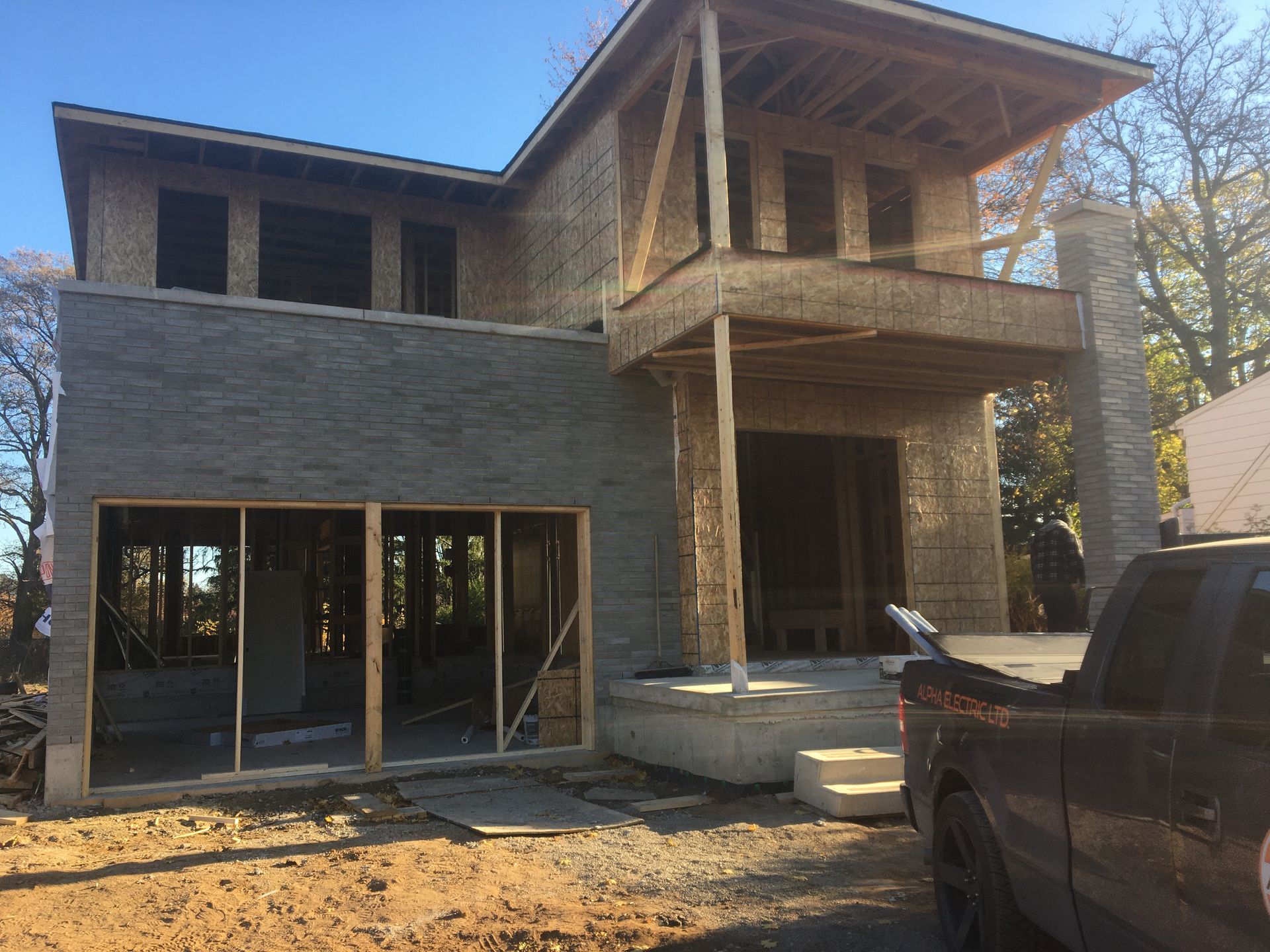 A truck is parked in front of a house under construction.