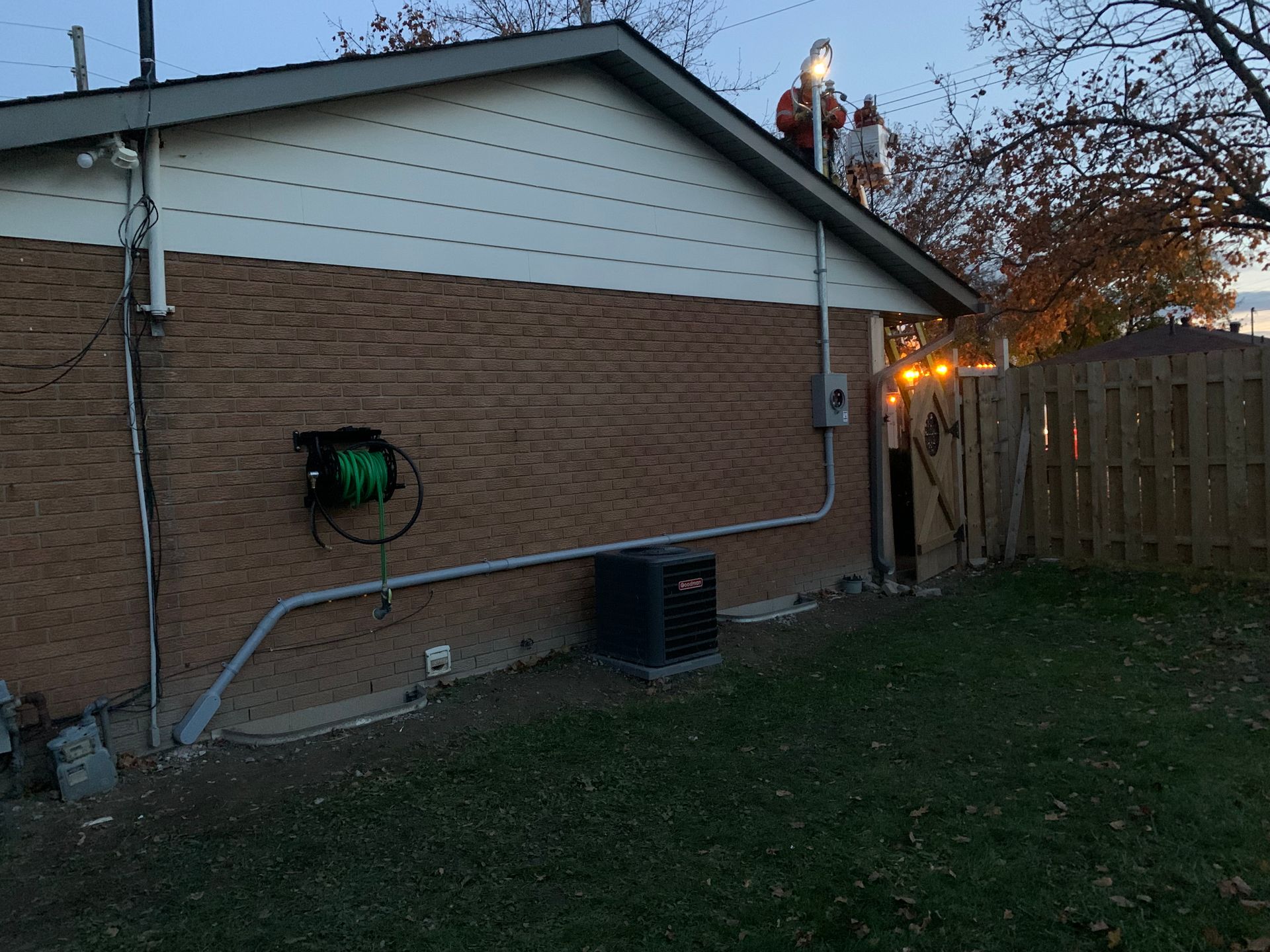 A brick house with a hose hanging on the side of it.