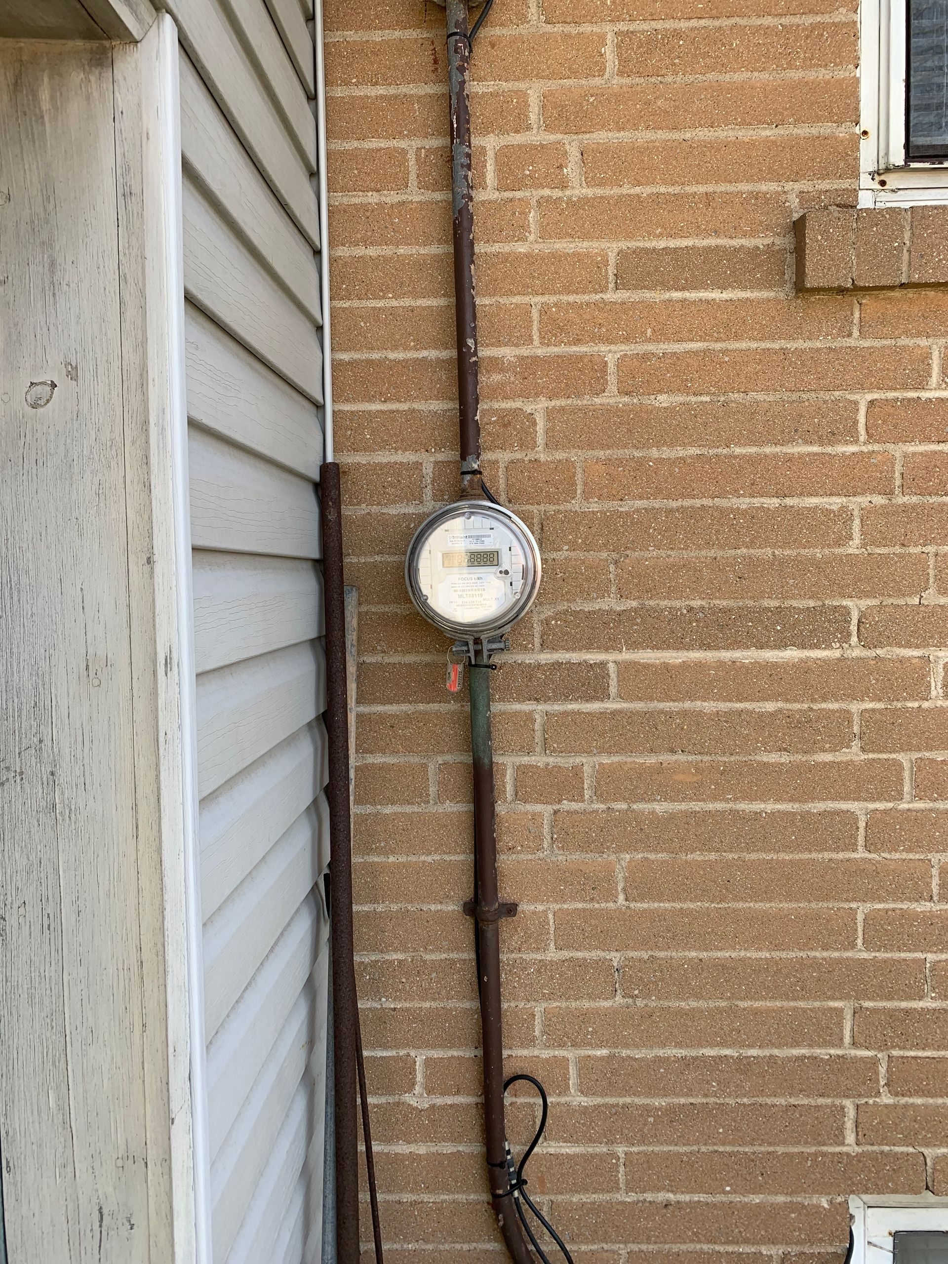 A clock is hanging on the side of a brick building.