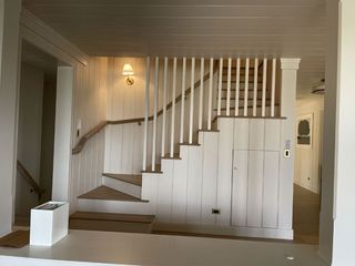 Interior staircase with white railing and wood steps in a hallway
