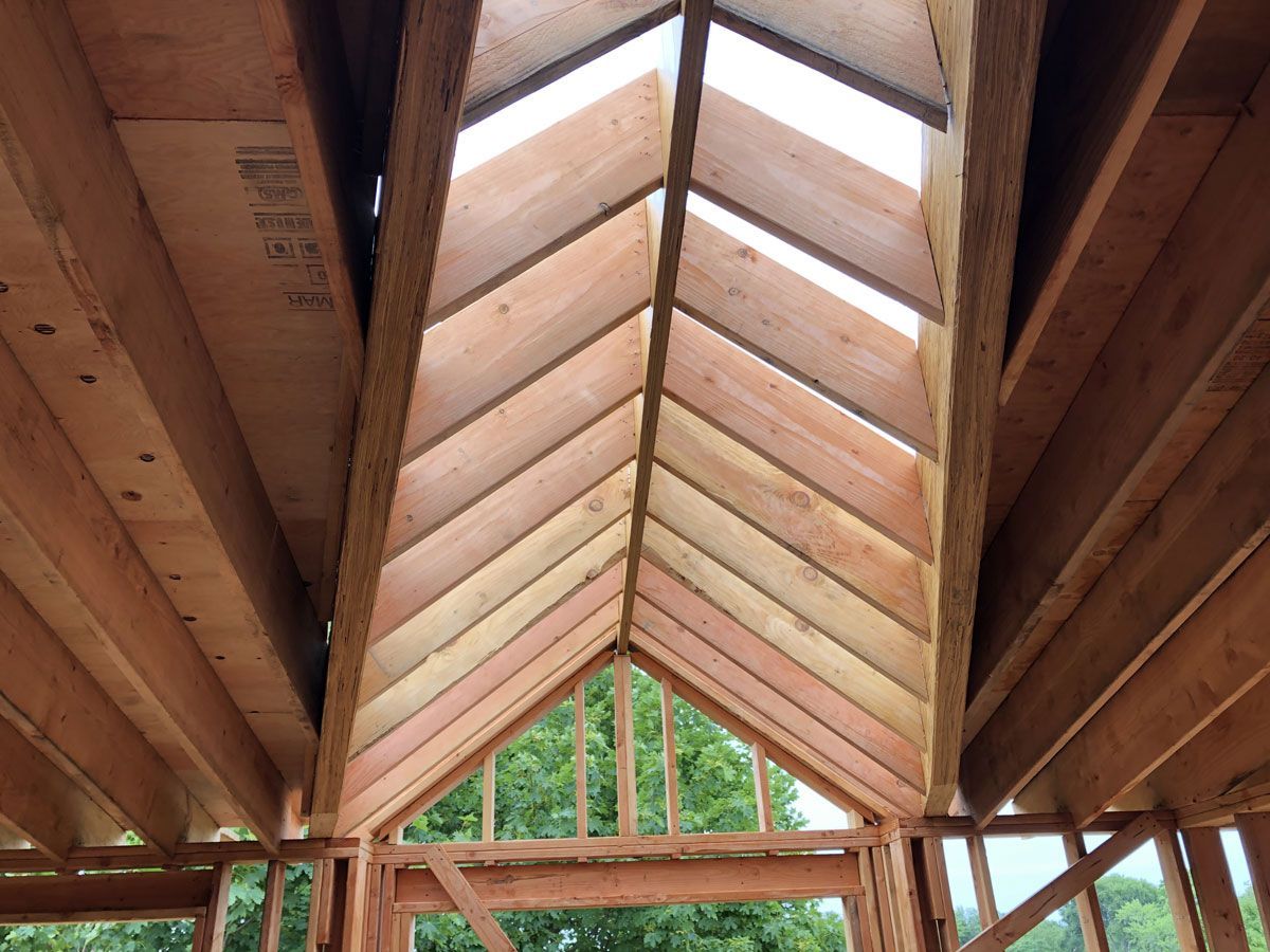 Wooden vaulted ceiling with exposed beams and a skylight at the roof peak