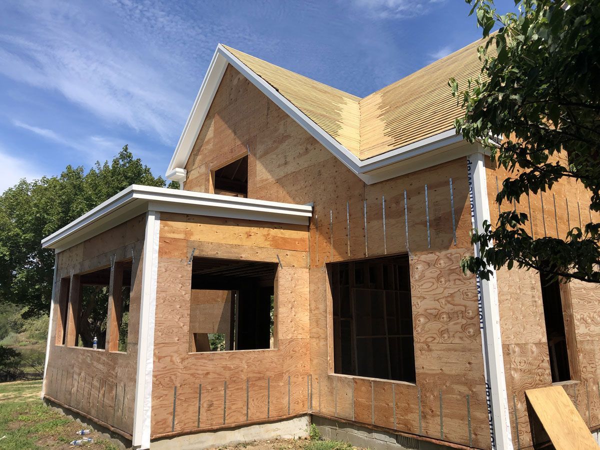 Partially built brick house with white trim under a blue sky