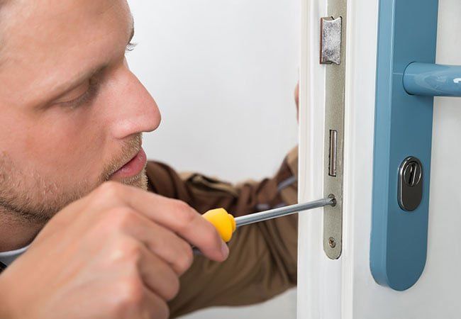 A 24 hour locksmith working on a door in Ashland, MO A 24 hour locksmith working on a door in Ashland, MO