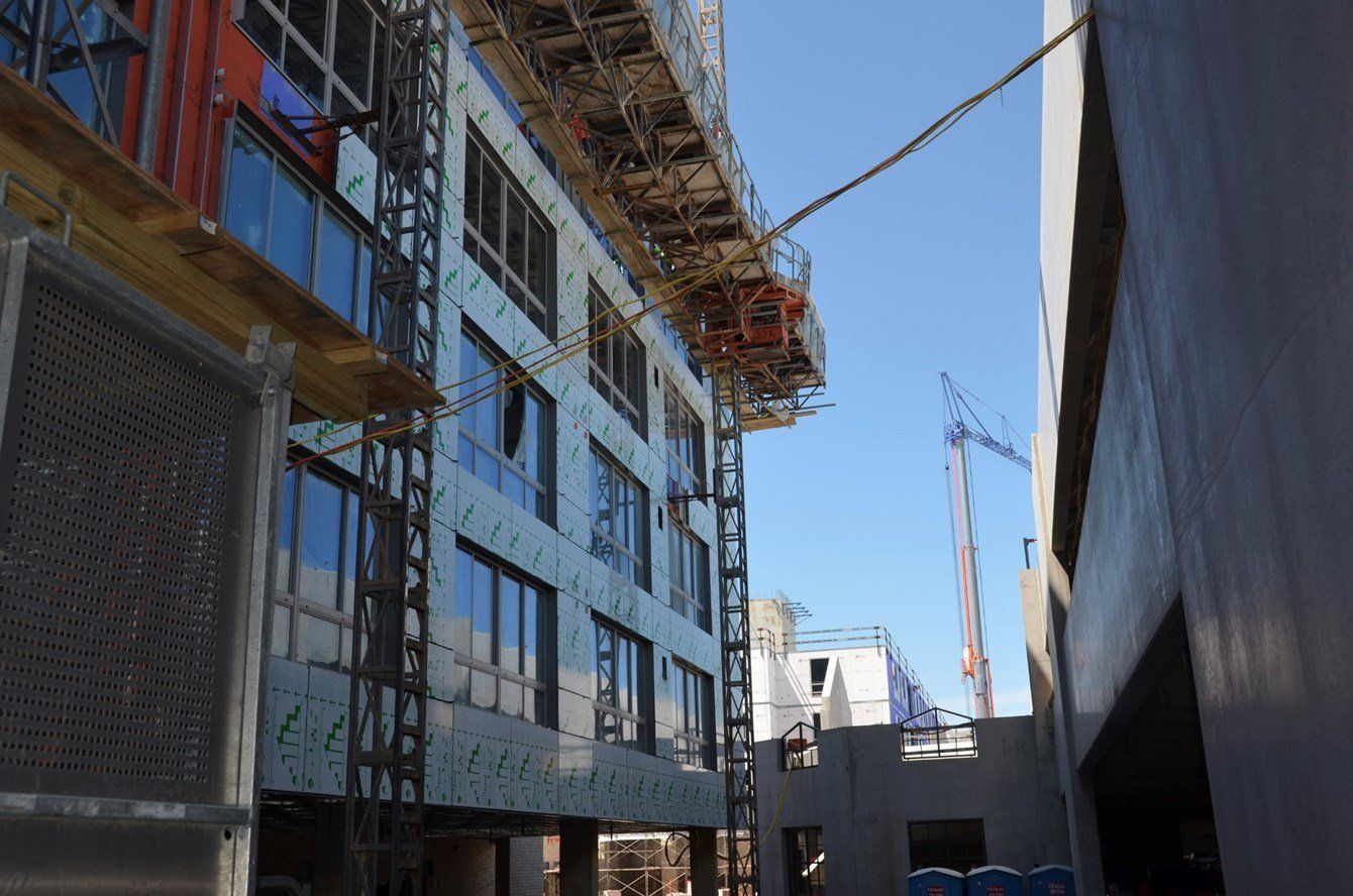 A building under construction with a blue sky in the background.
