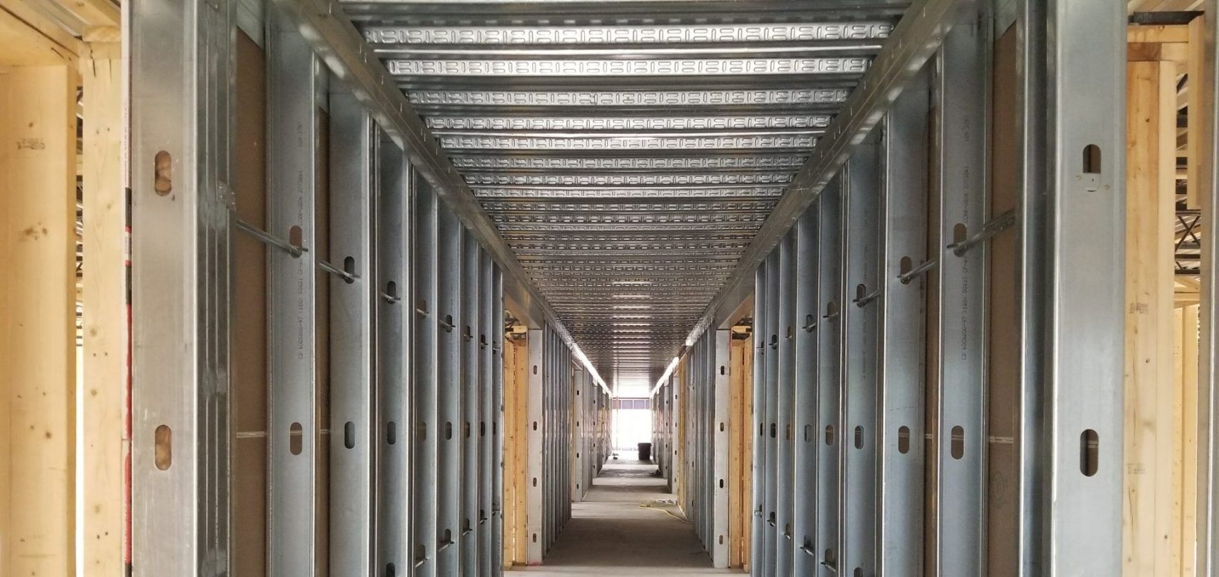 A long hallway with steel beams in a building under construction.