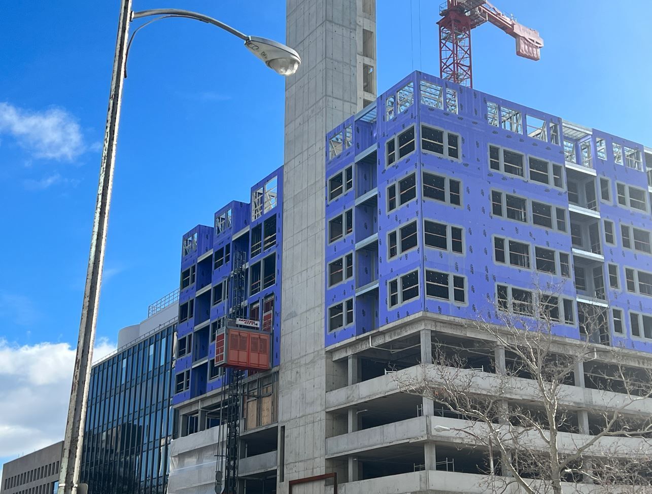 A large building under construction with a crane in front of it.