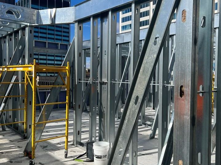 A yellow scaffolding is sitting in front of a building under construction.