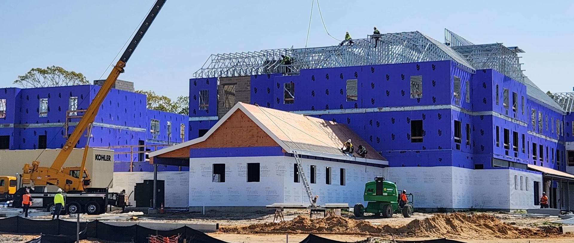 A large building under construction with a crane in front of it.