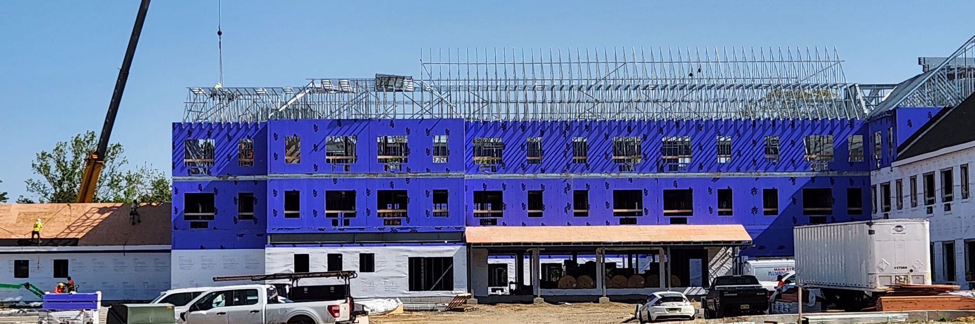 A large building under construction with a crane in the background.