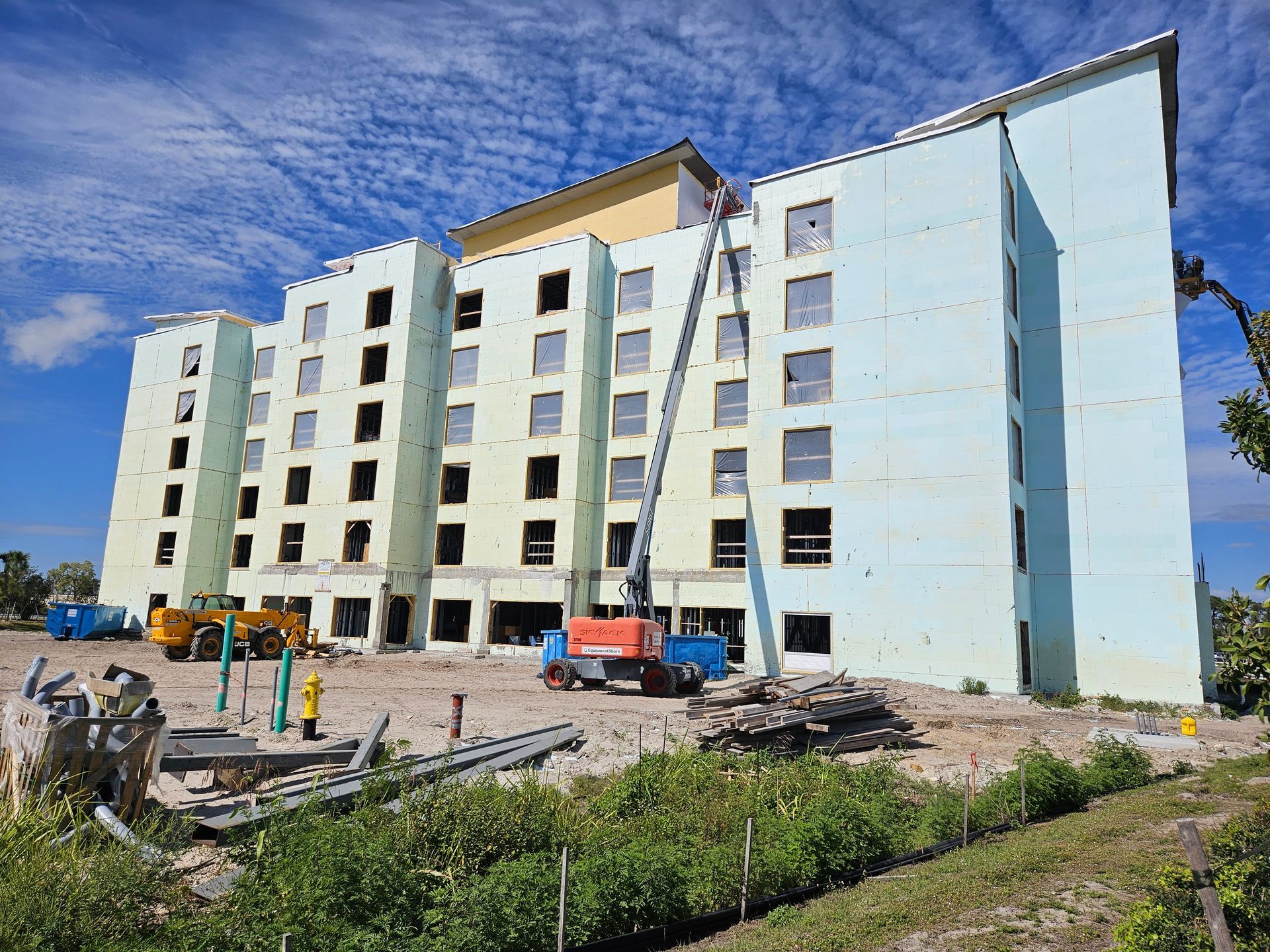 A large building is being built on a sunny day.