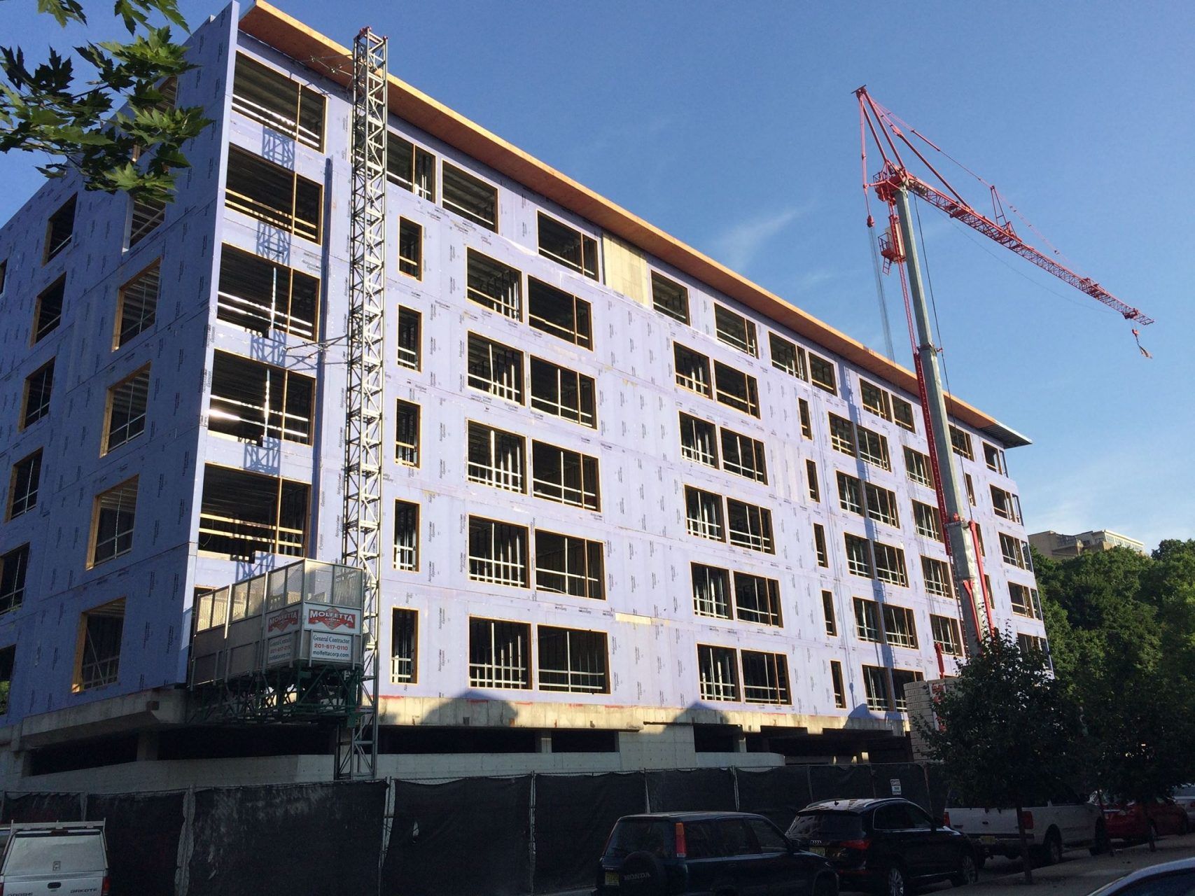 A large building under construction with a crane in front of it.
