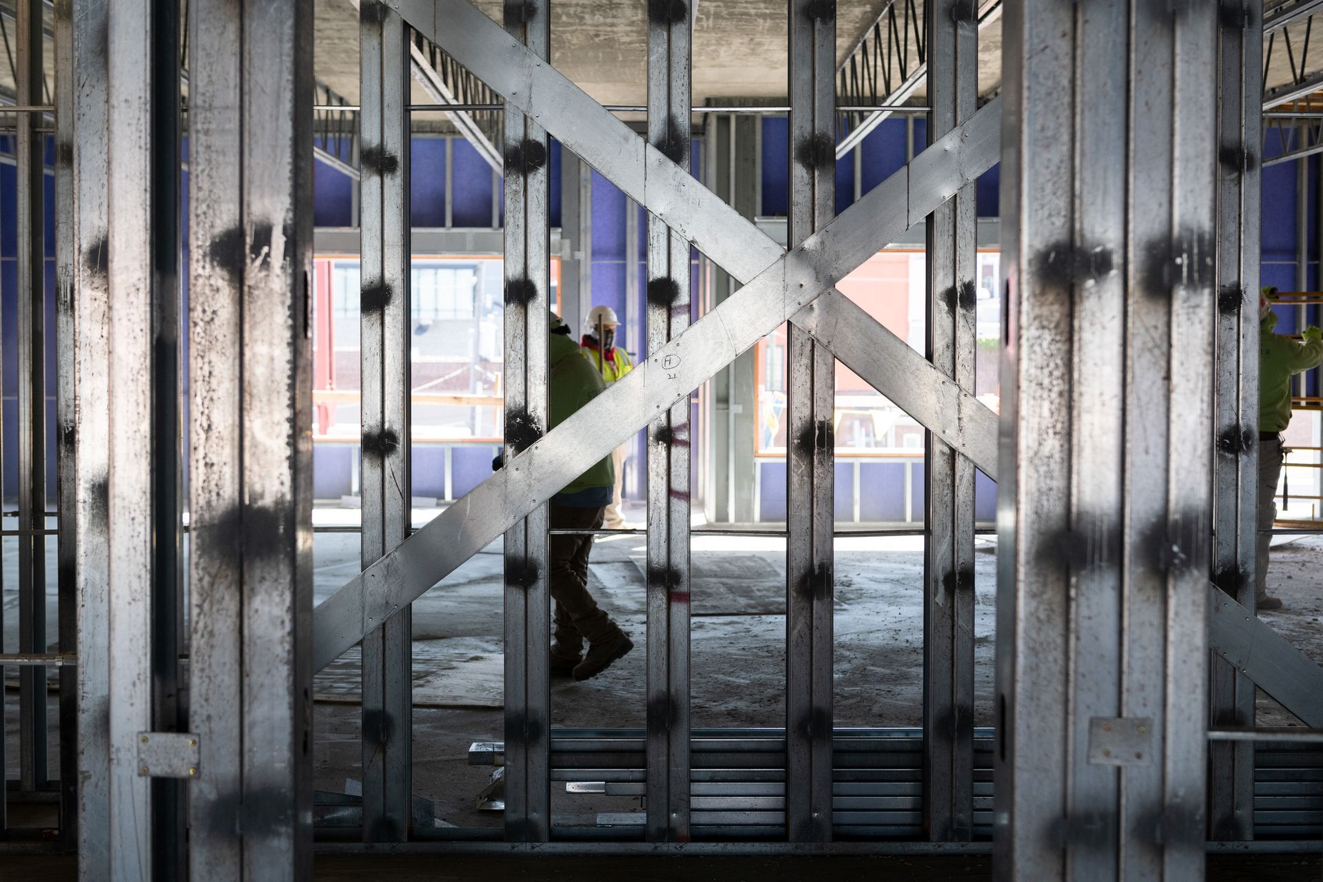 A man is walking through a building under construction.