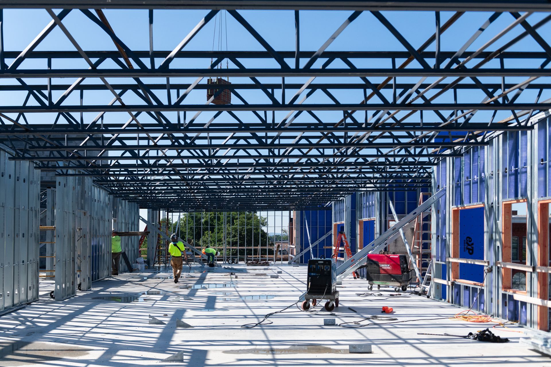 A group of construction workers are working on a large building under construction.