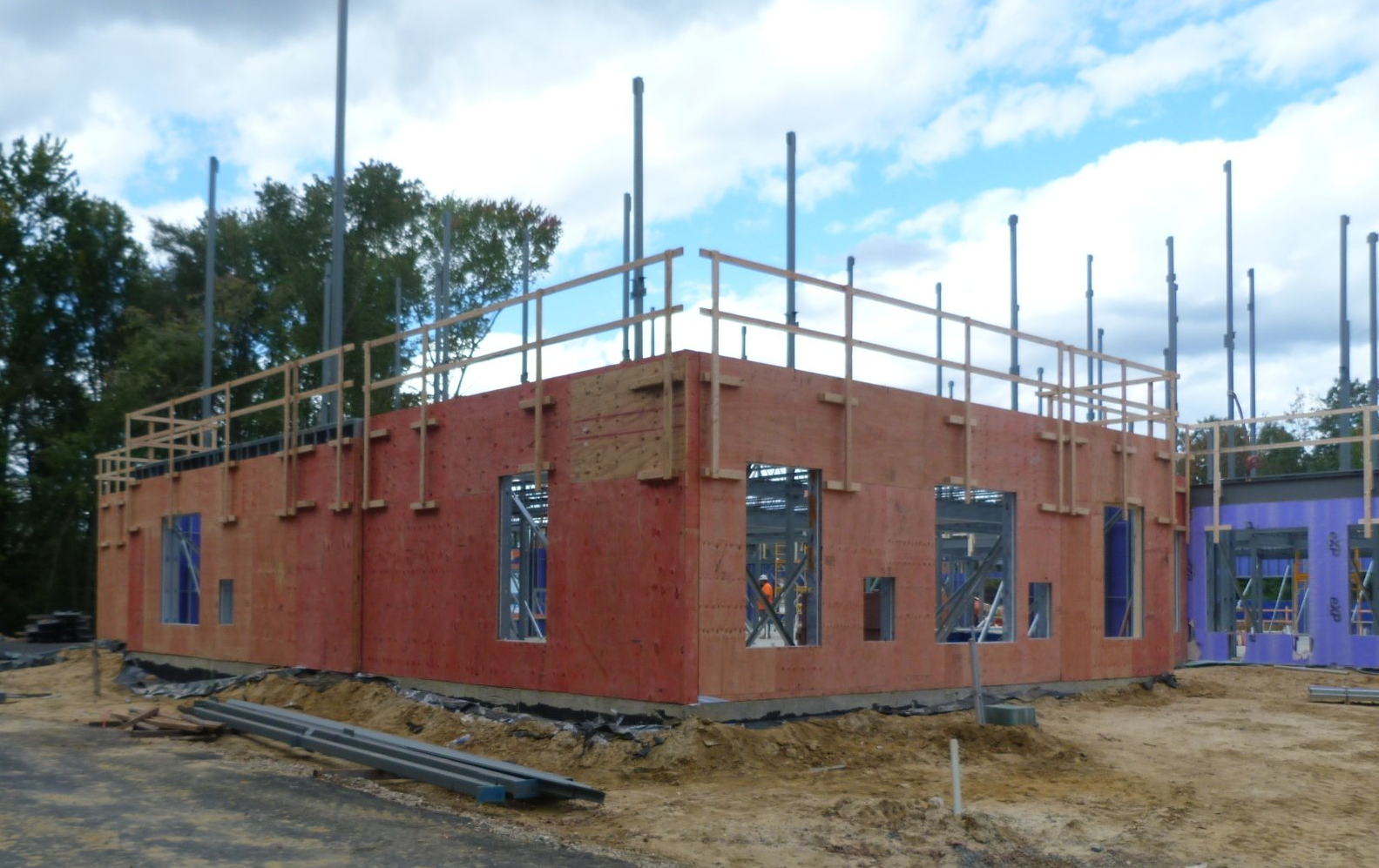 A large brick building under construction with scaffolding on top.
