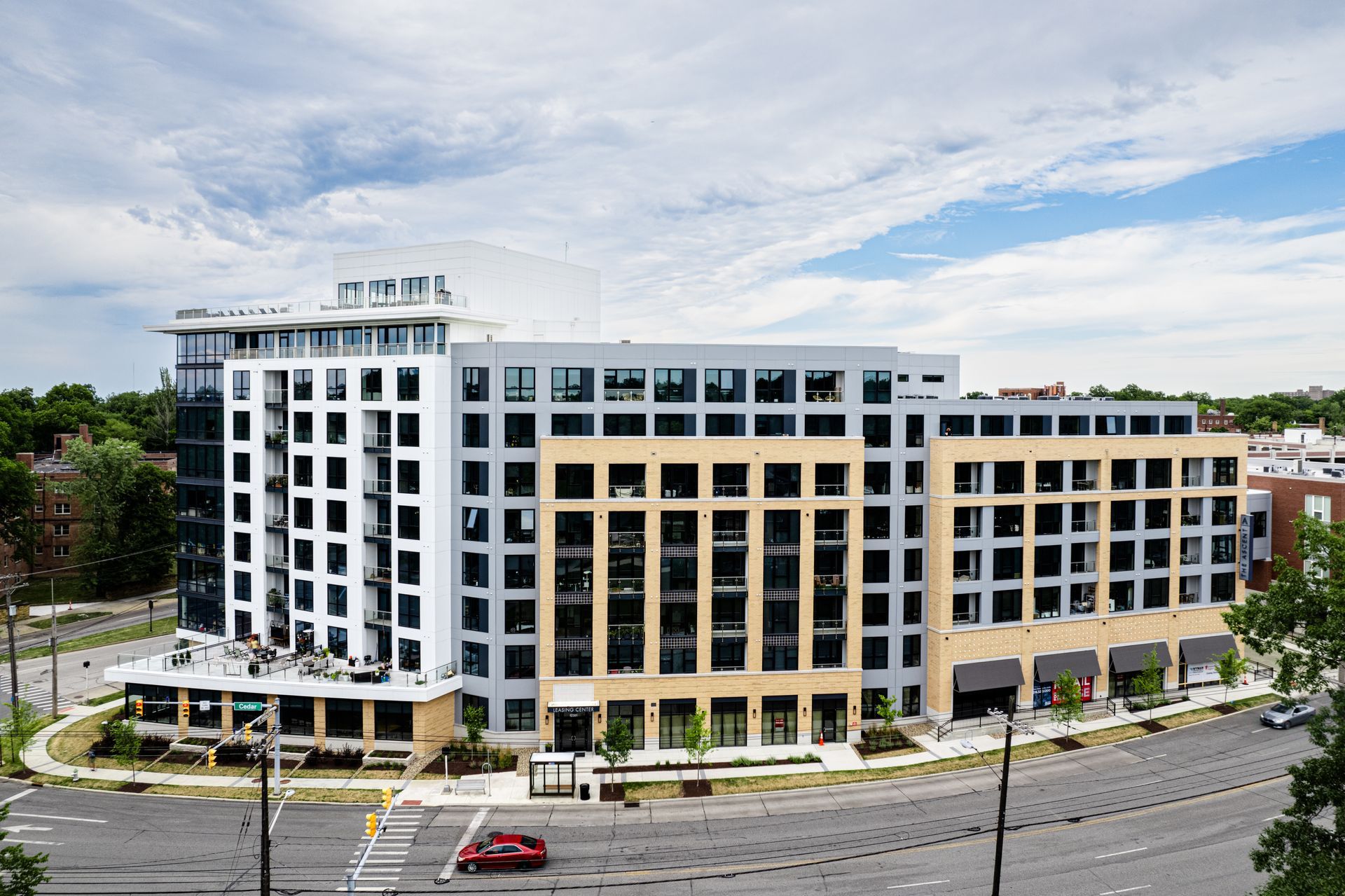 An aerial view of a large building with a red car parked in front of it.