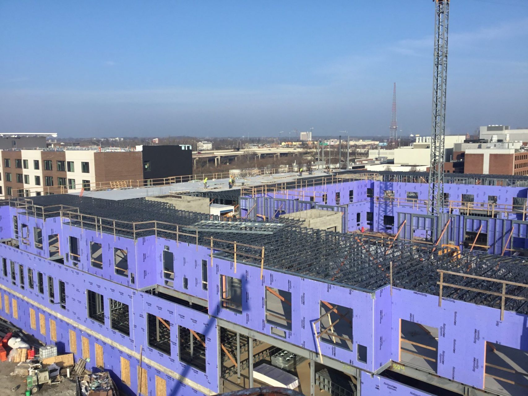 A large purple building is being built in a city.