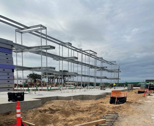A large metal structure is being built on a cloudy day.