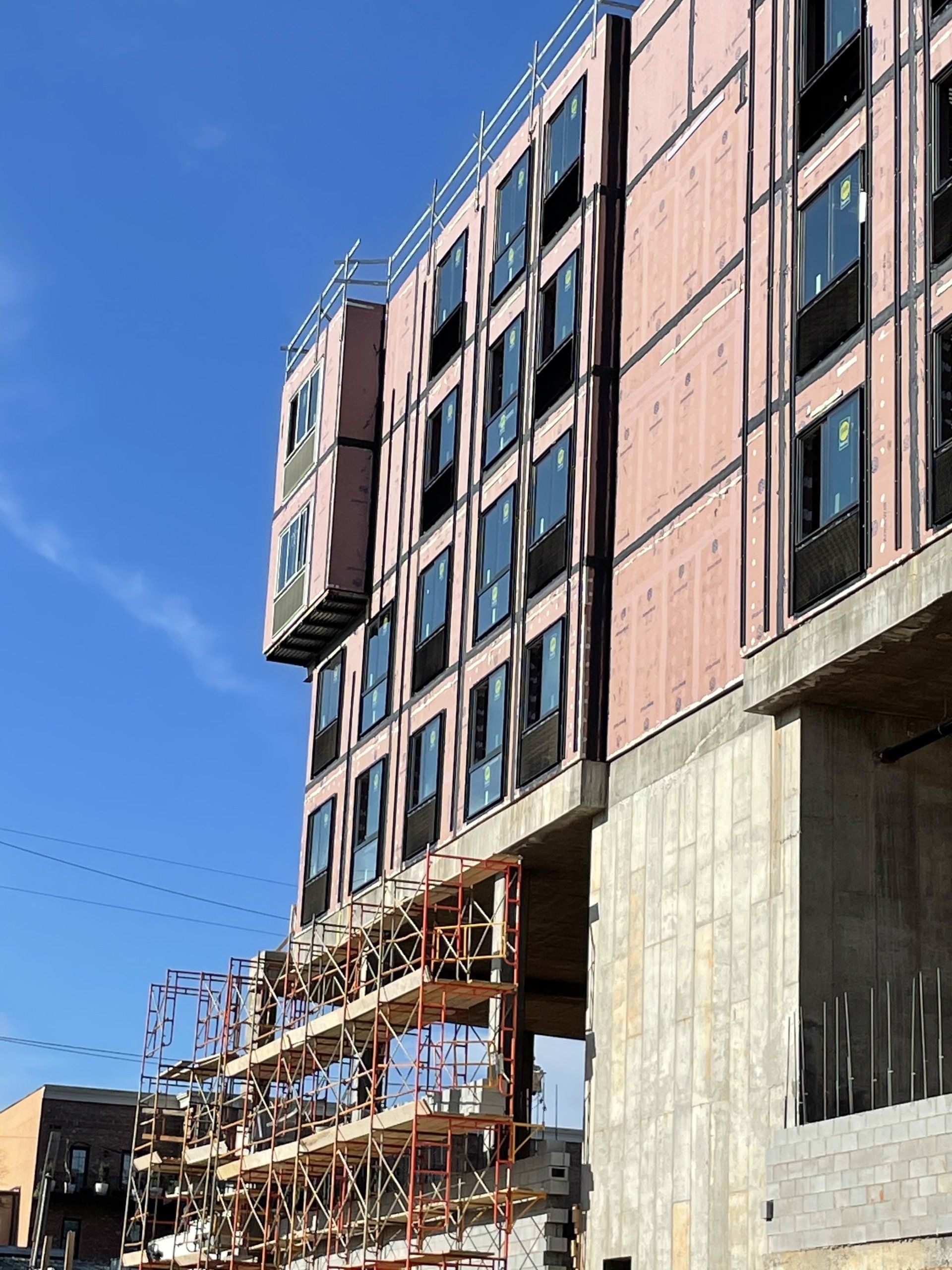 A large building under construction with a blue sky in the background.
