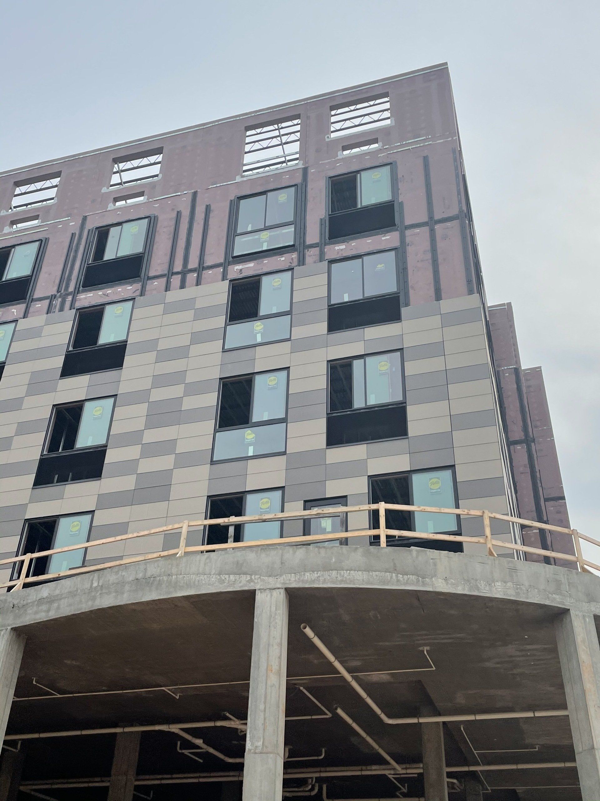A large building with a lot of windows is under construction.