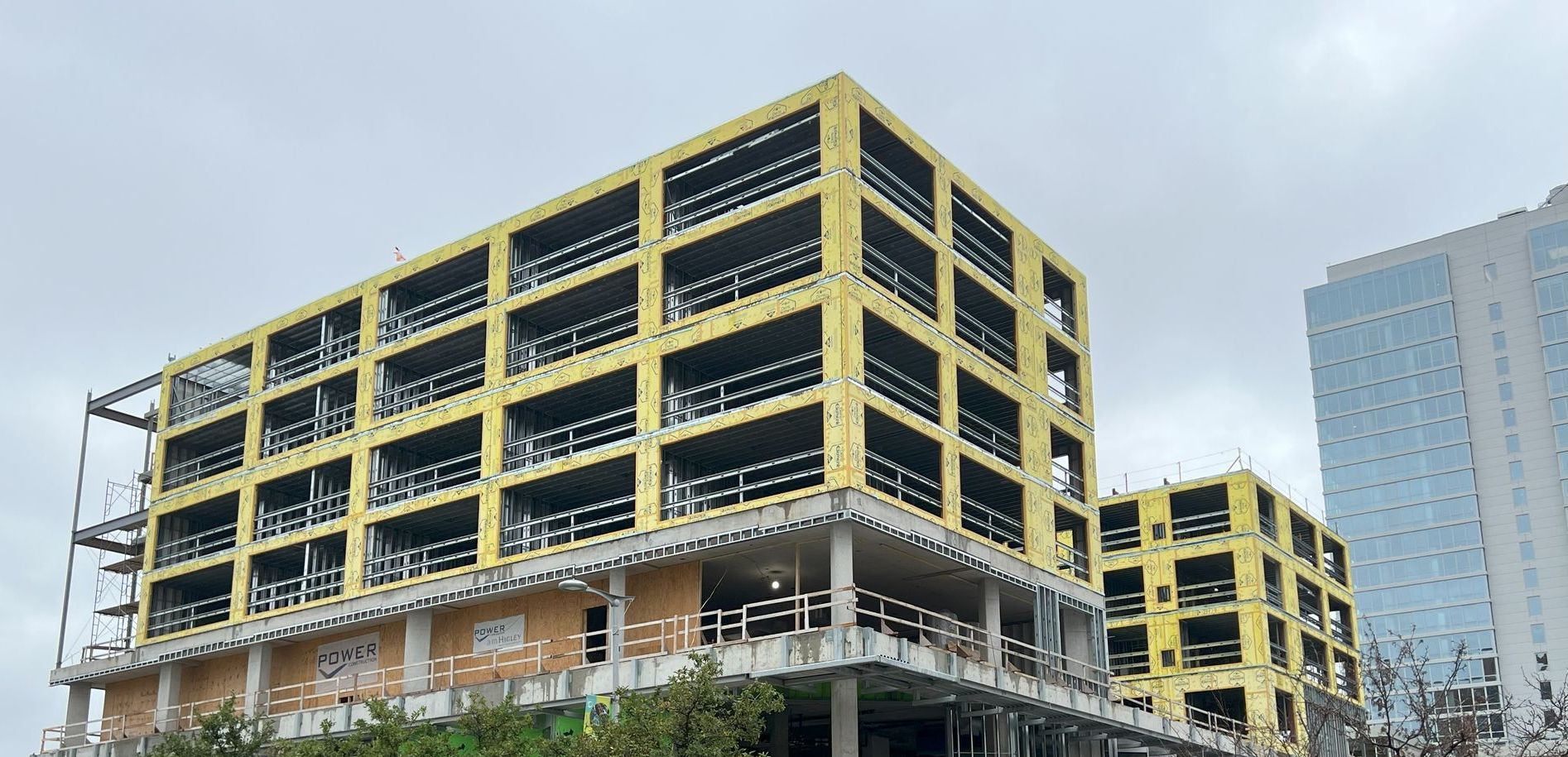 A large building with a lot of windows is under construction.
