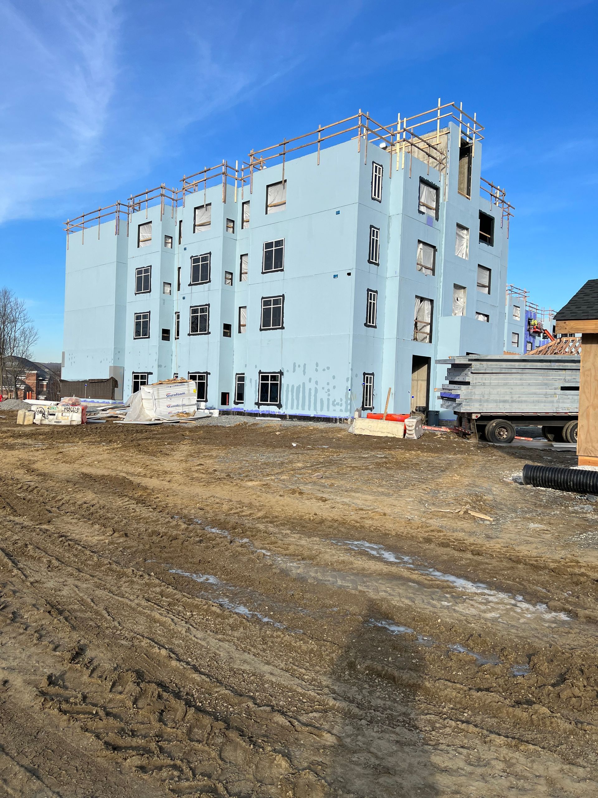 A large building is being built in a dirt field.