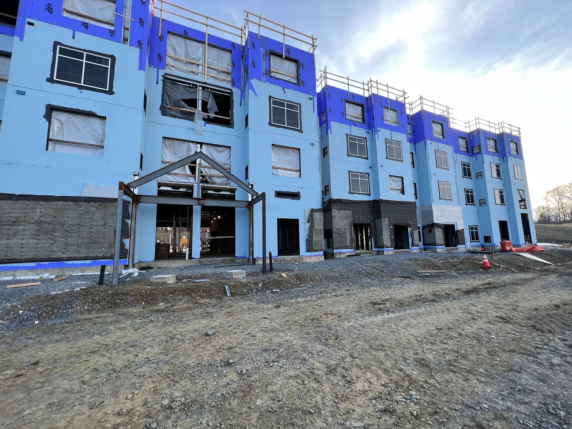 A large blue building under construction with a lot of windows.