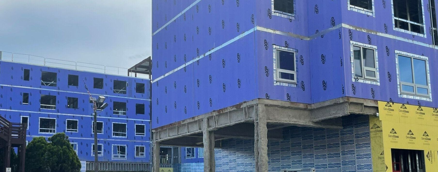 A blue and yellow building under construction with a lot of windows.
