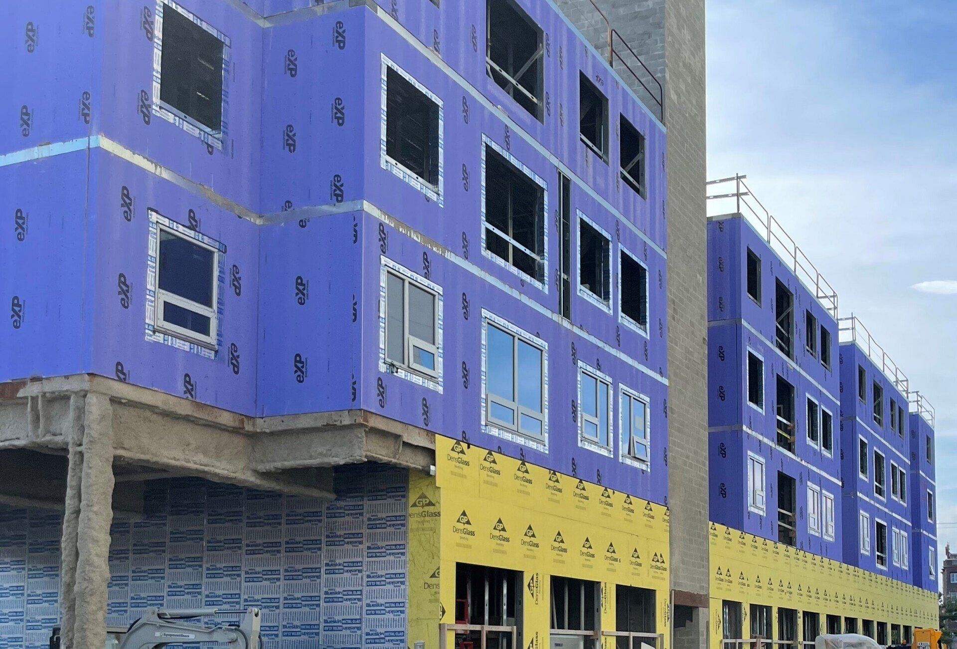 A building under construction with a blue and yellow facade.