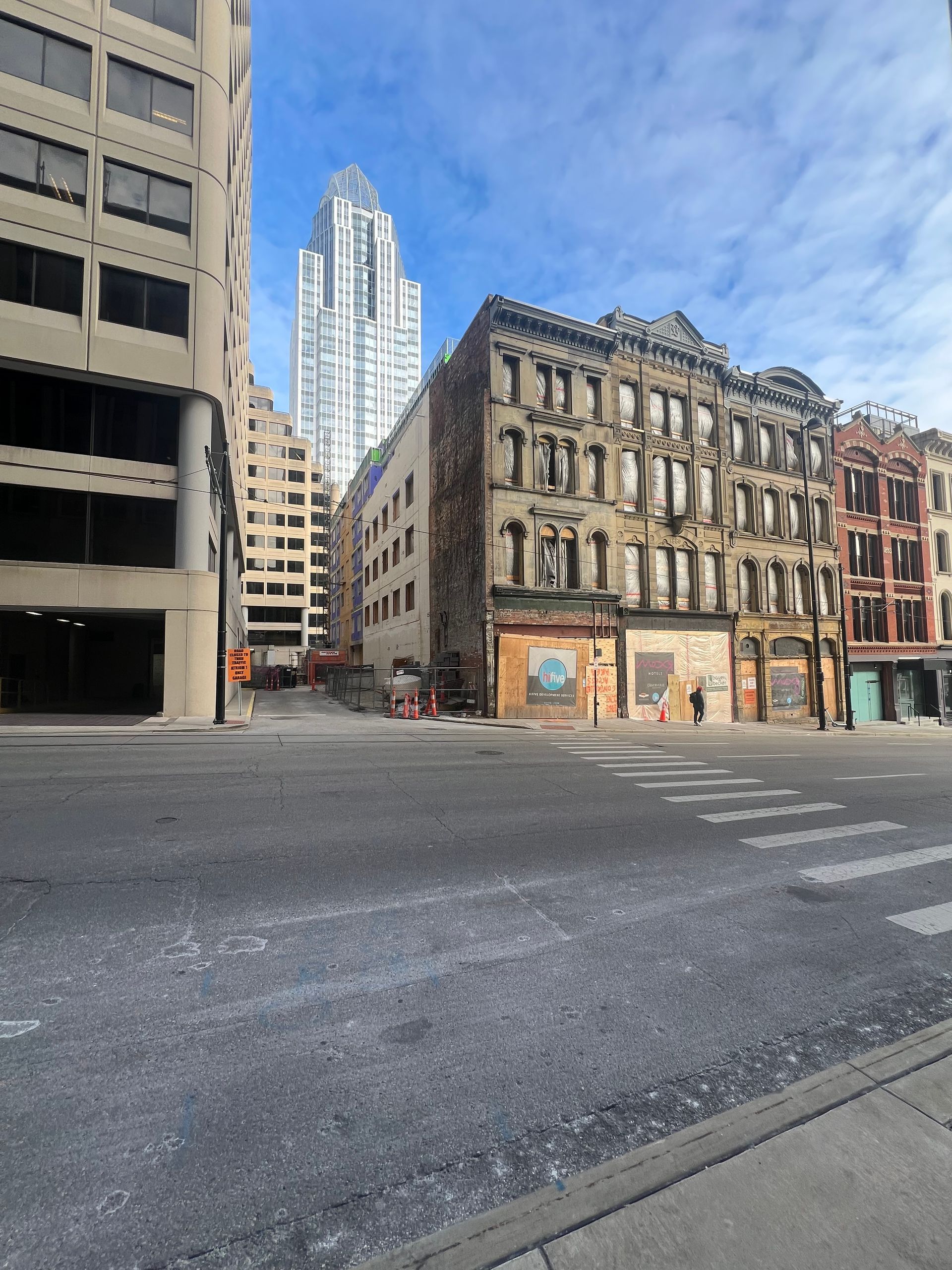 A city street with a lot of buildings and a skyscraper in the background.