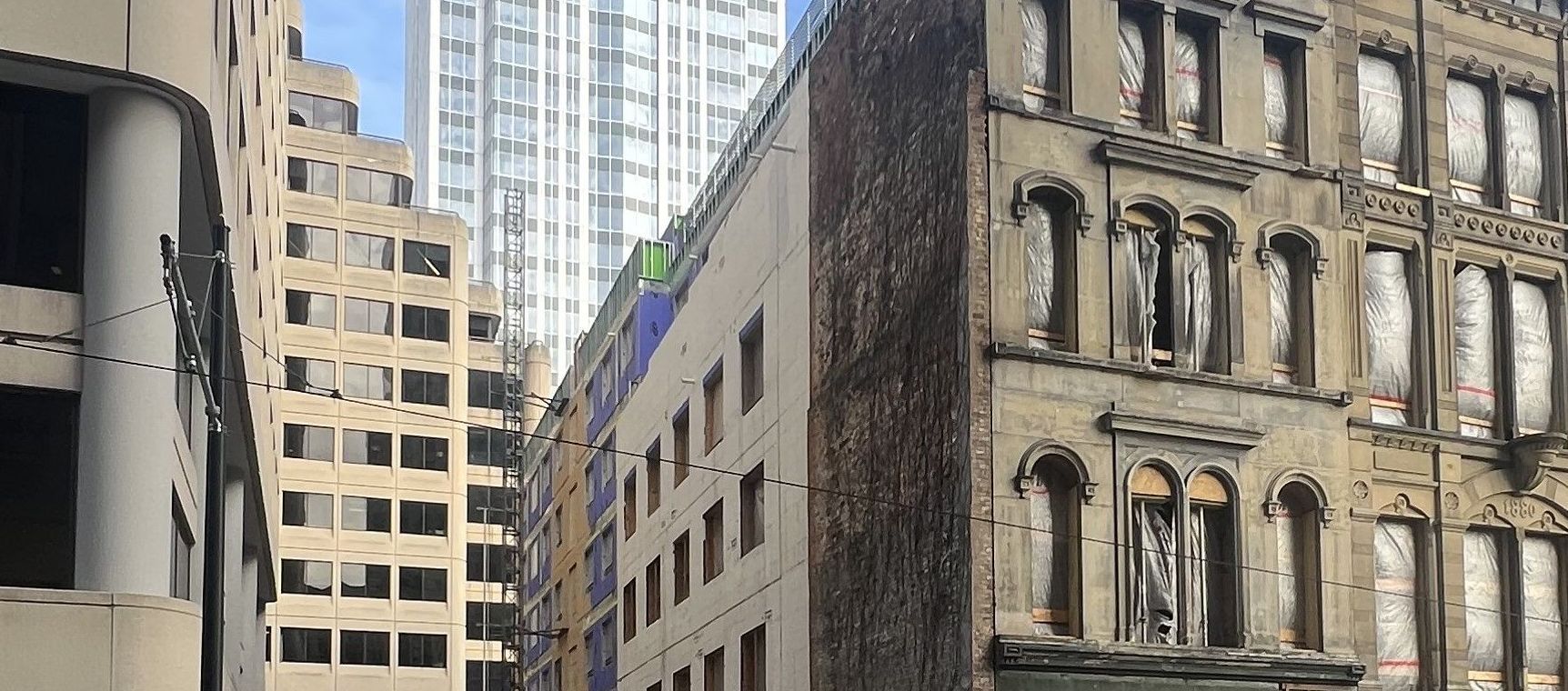 A row of tall buildings are lined up on a city street.