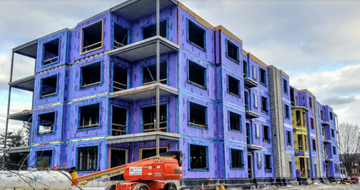 A large building under construction with a crane in front of it.
