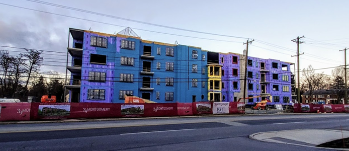 A large building is being built on the side of the road.