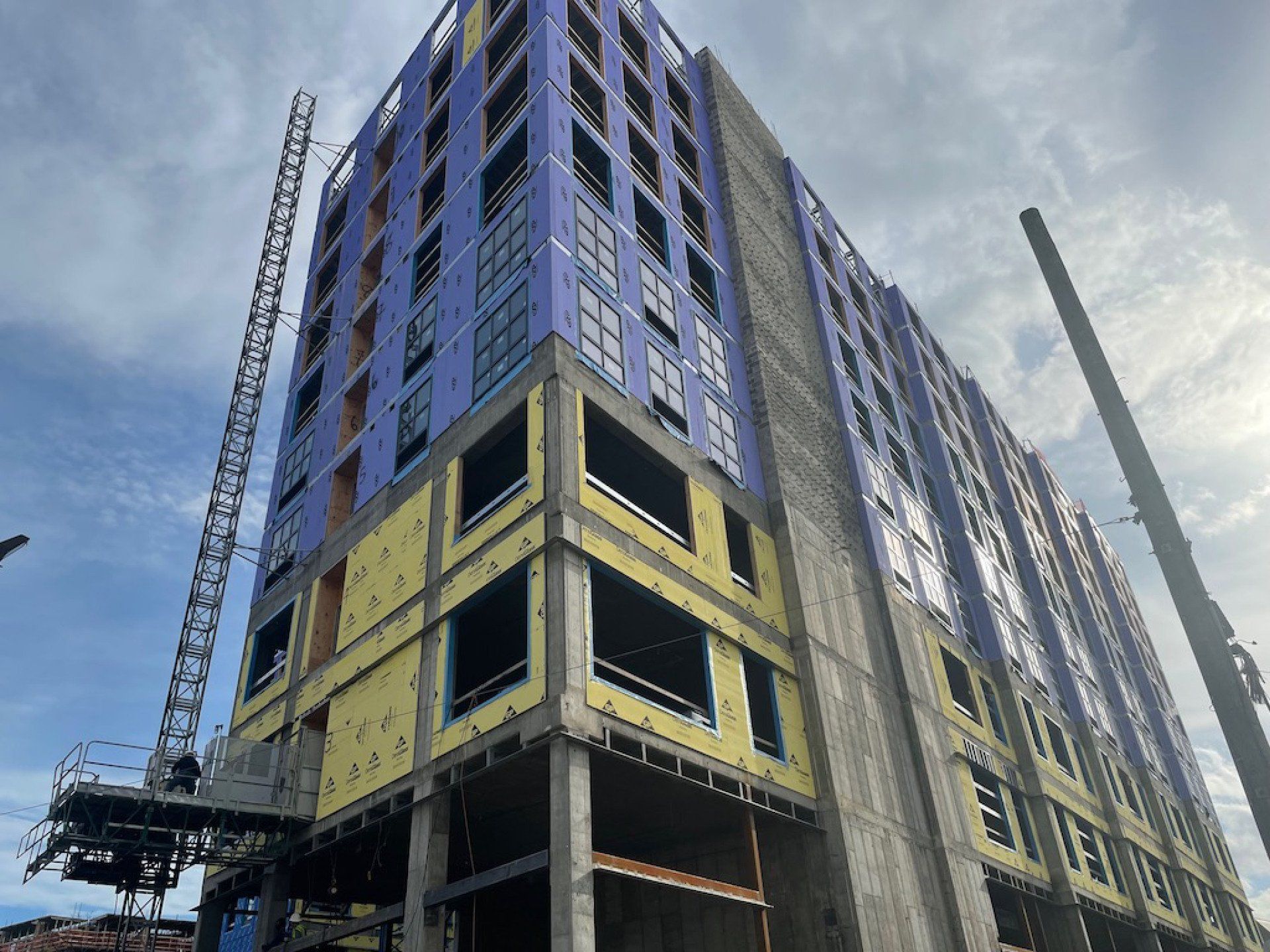 A large building under construction with a crane in the background.