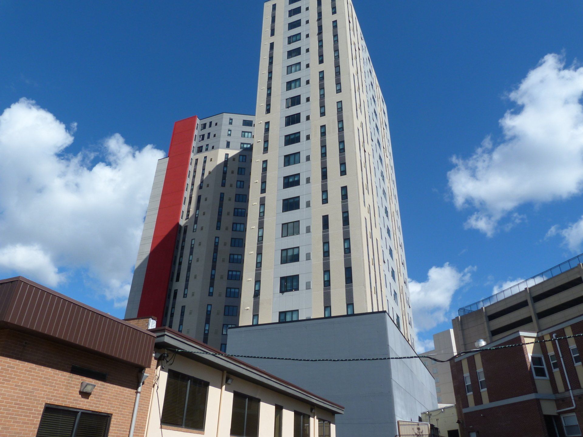 A tall building with a red stripe on the side of it.