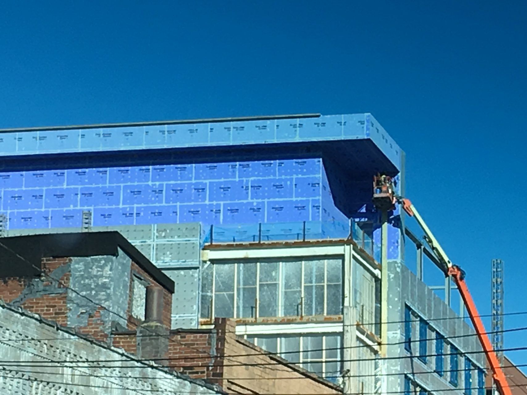 A building is being built with a crane beside it.