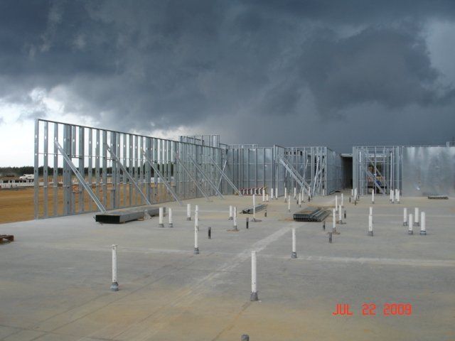 A building under construction with a cloudy sky in the background.