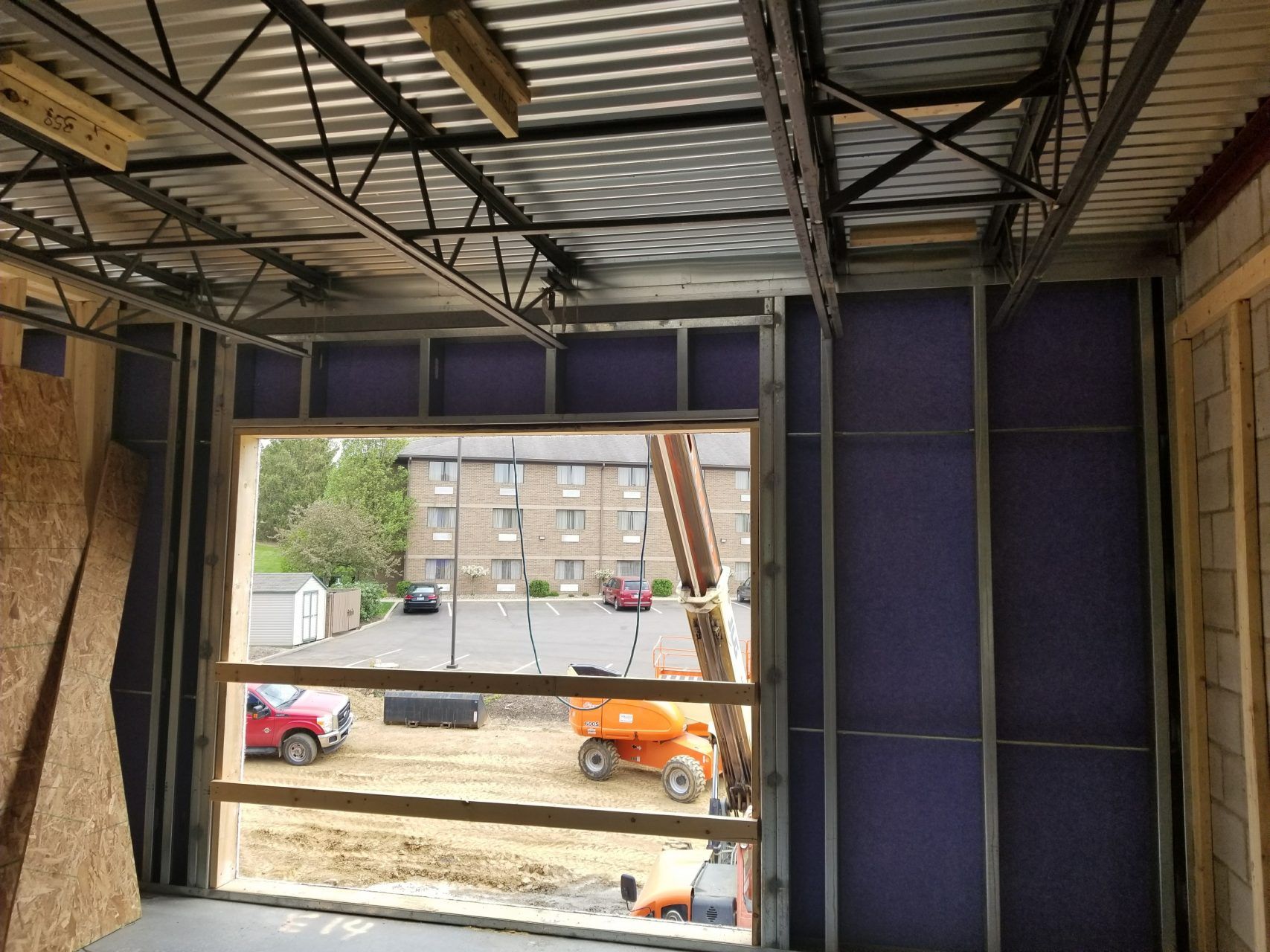 A building under construction with a view of a parking lot.