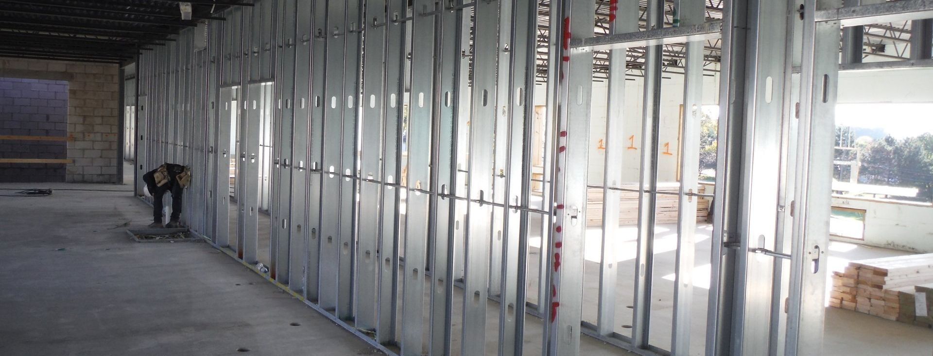 A man is working on a wall in a building under construction.