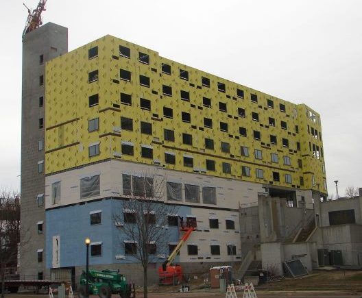 A large building is being built with yellow insulation