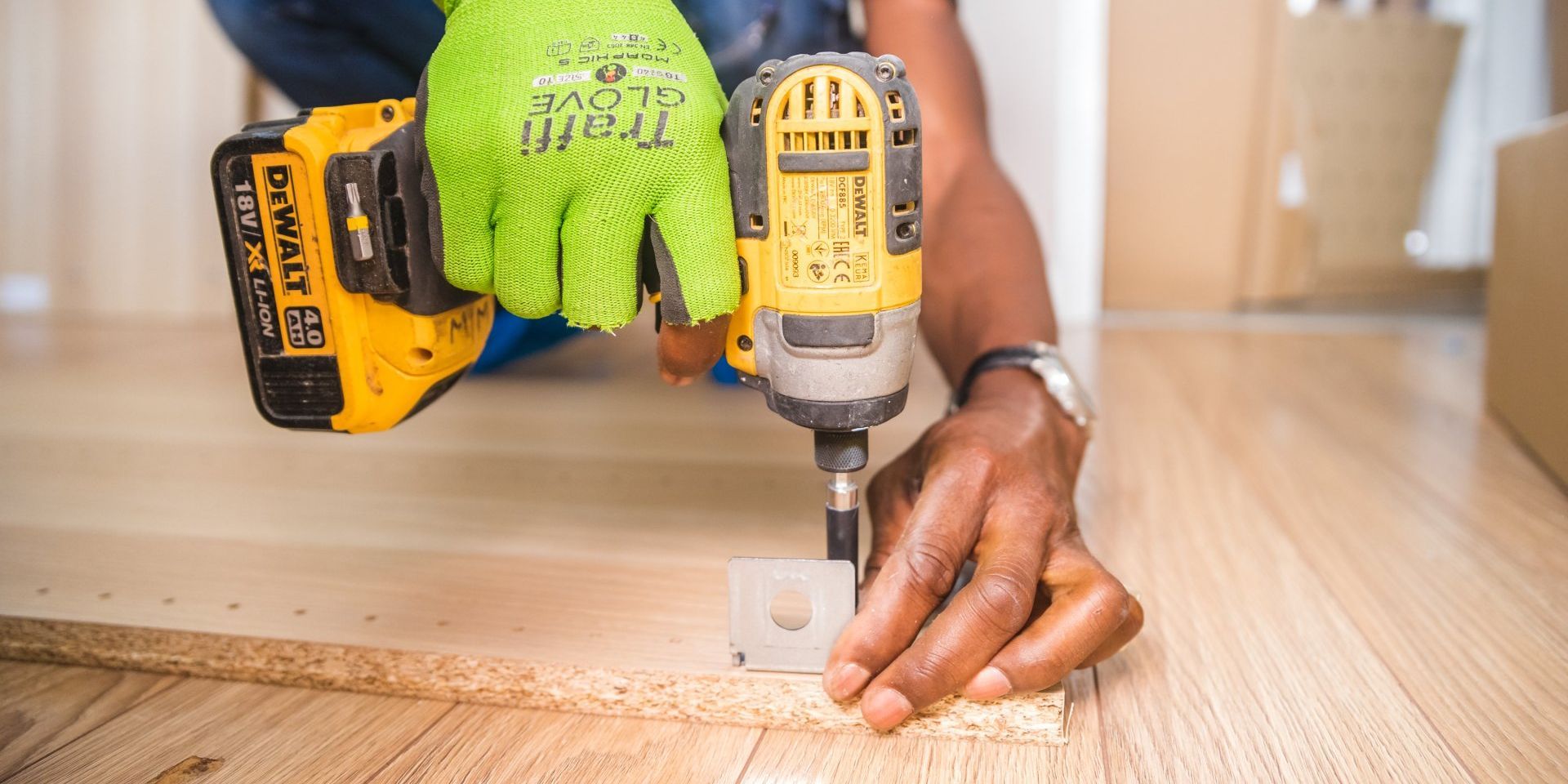 A person is using a drill on a piece of wood.