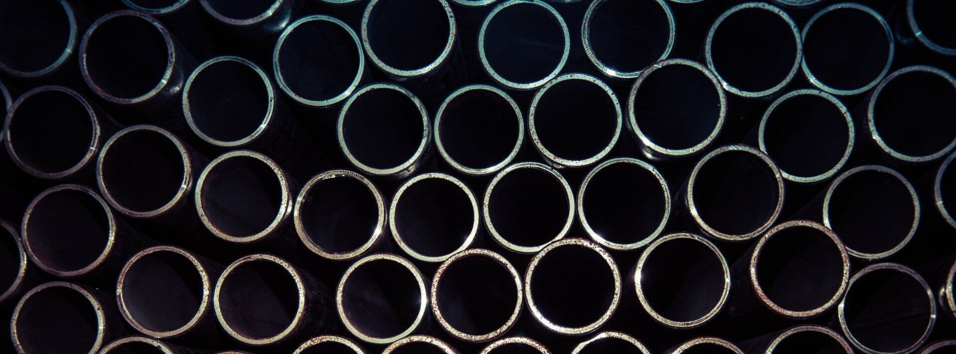 A bunch of metal pipes stacked on top of each other.