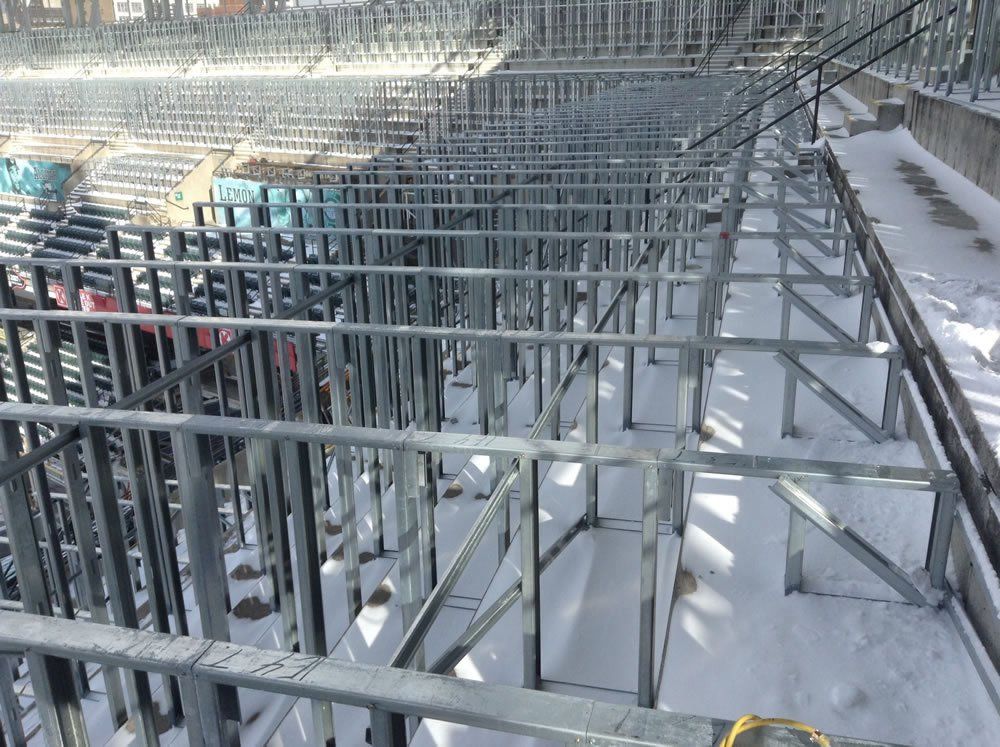 A large metal structure is being built in the snow.
