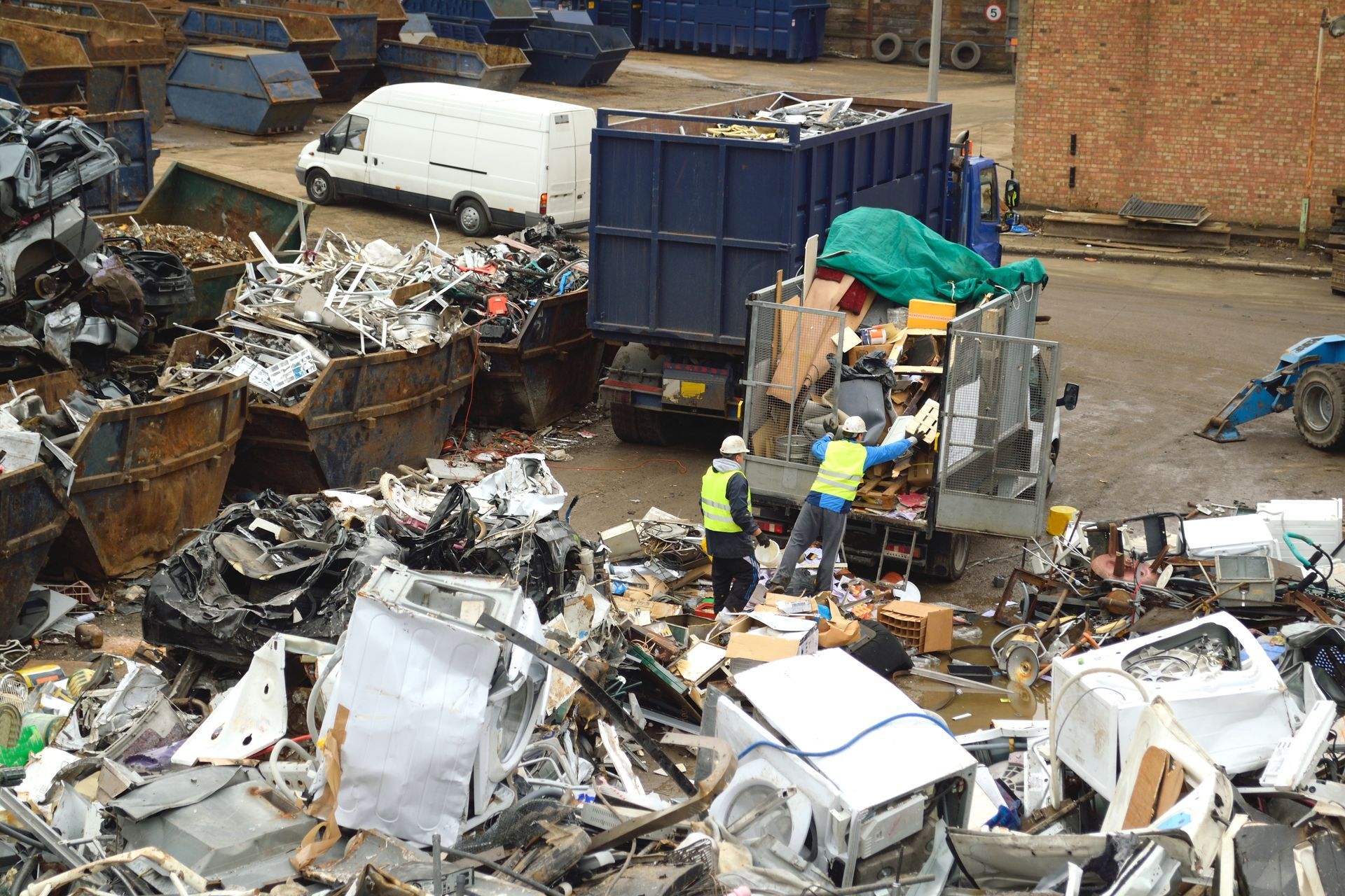 Workers in safety gear loading debris onto a truck for efficient scrap recycling services. Workers in safety gear loading debris onto a truck for efficient scrap recycling services.