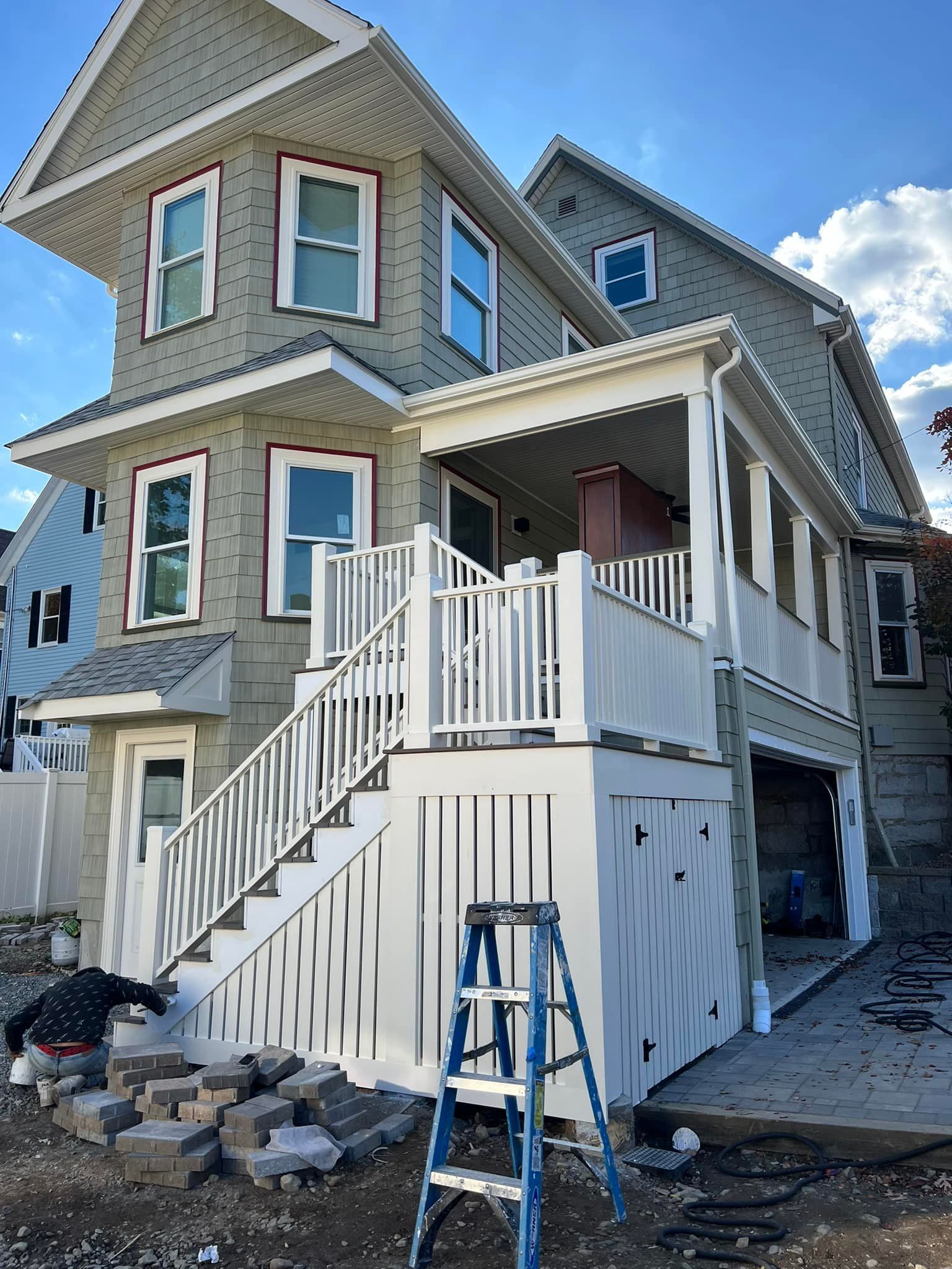 A ladder is sitting in front of a house under construction.