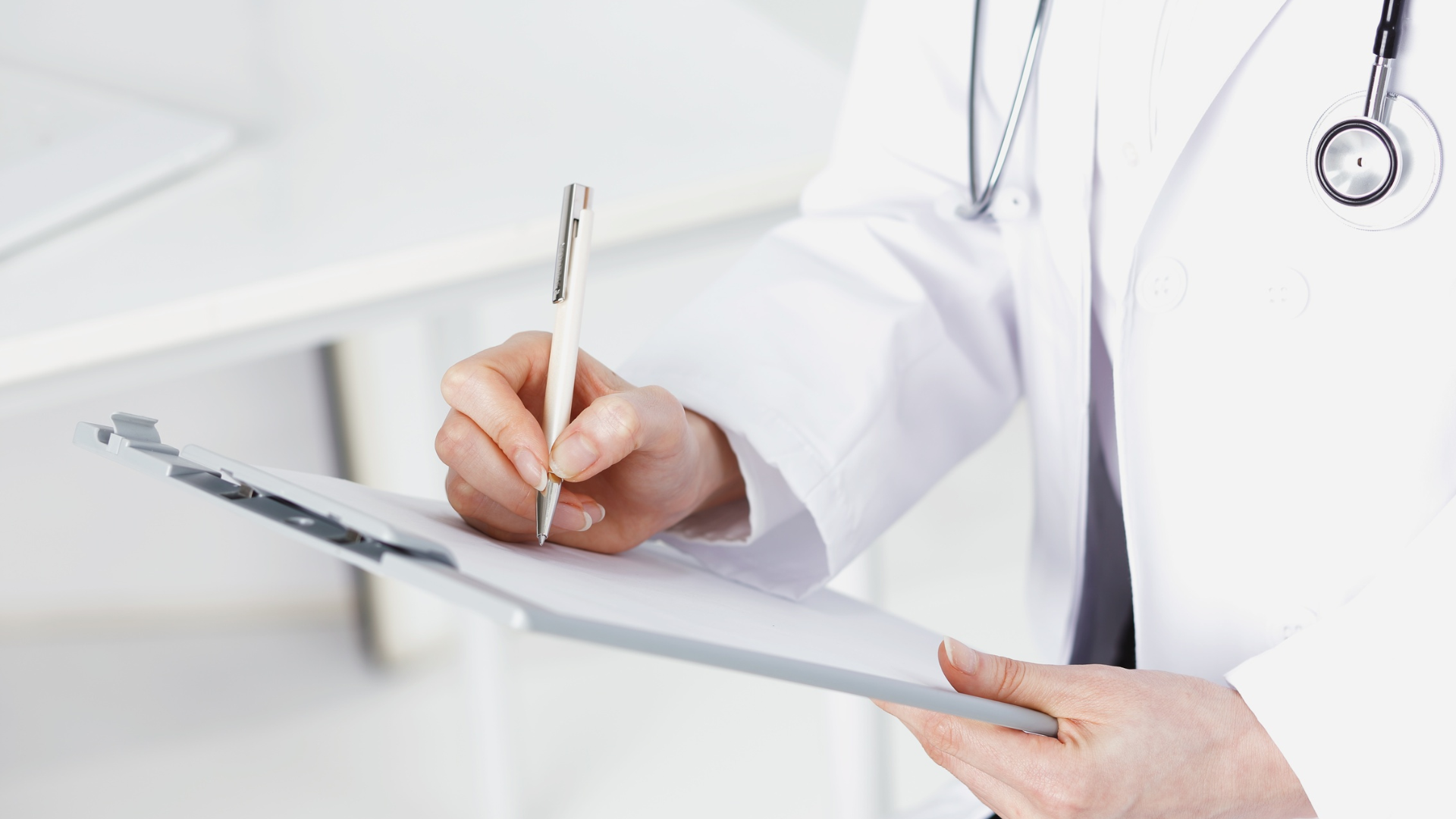Doctor writing on a clipboard in a bright medical office