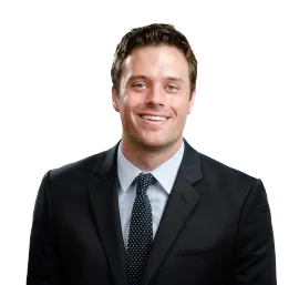 Smiling man in a dark suit and tie against a white background