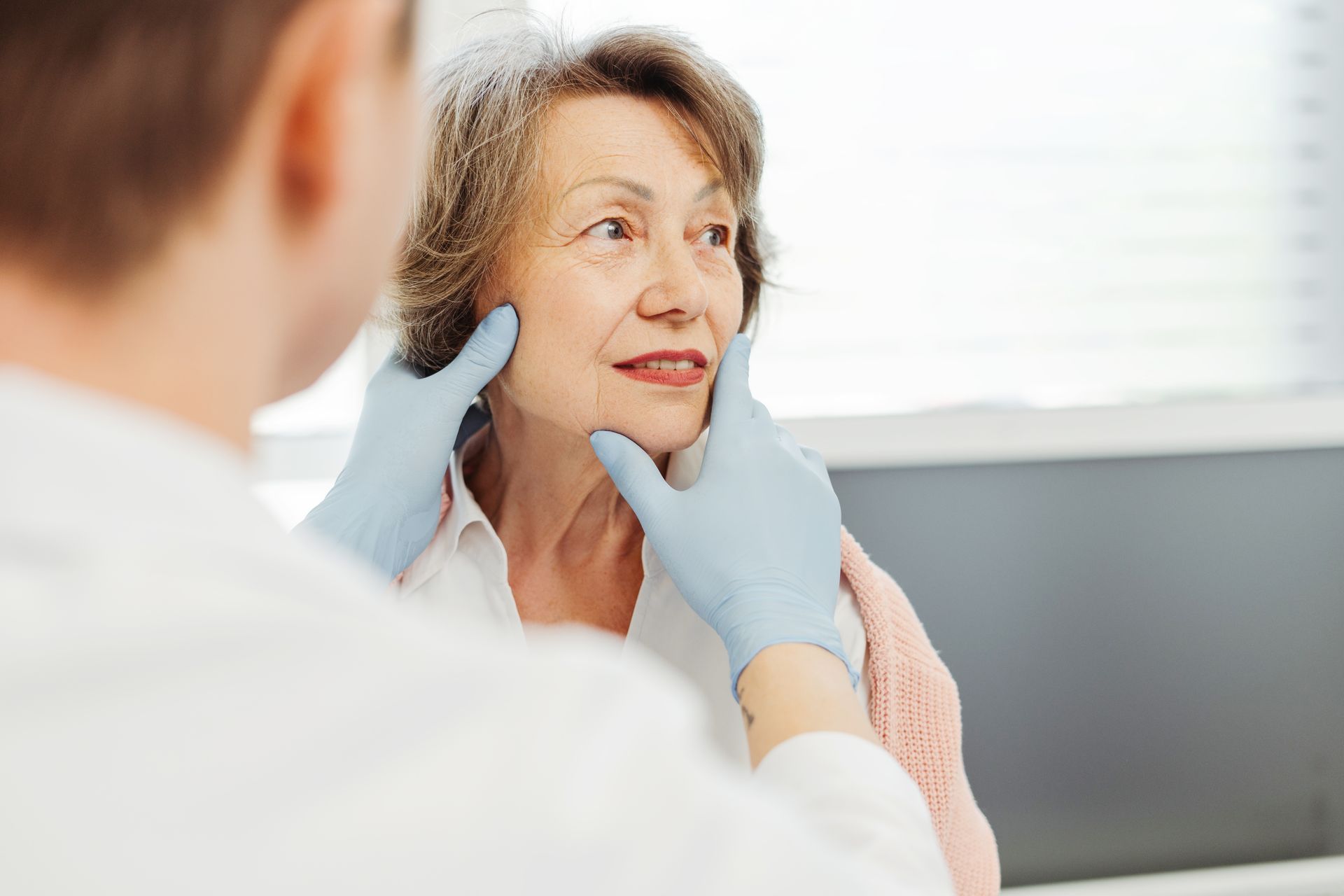 Doctor examining a patient’s throat in a bright clinic room