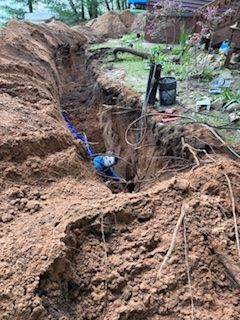 A large hole in the ground with a blue pipe in it.