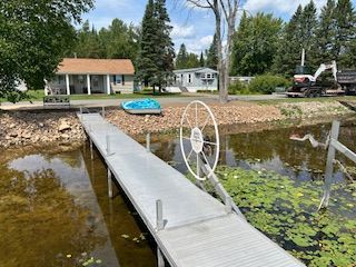 A dock with a boat on it and a house in the background.